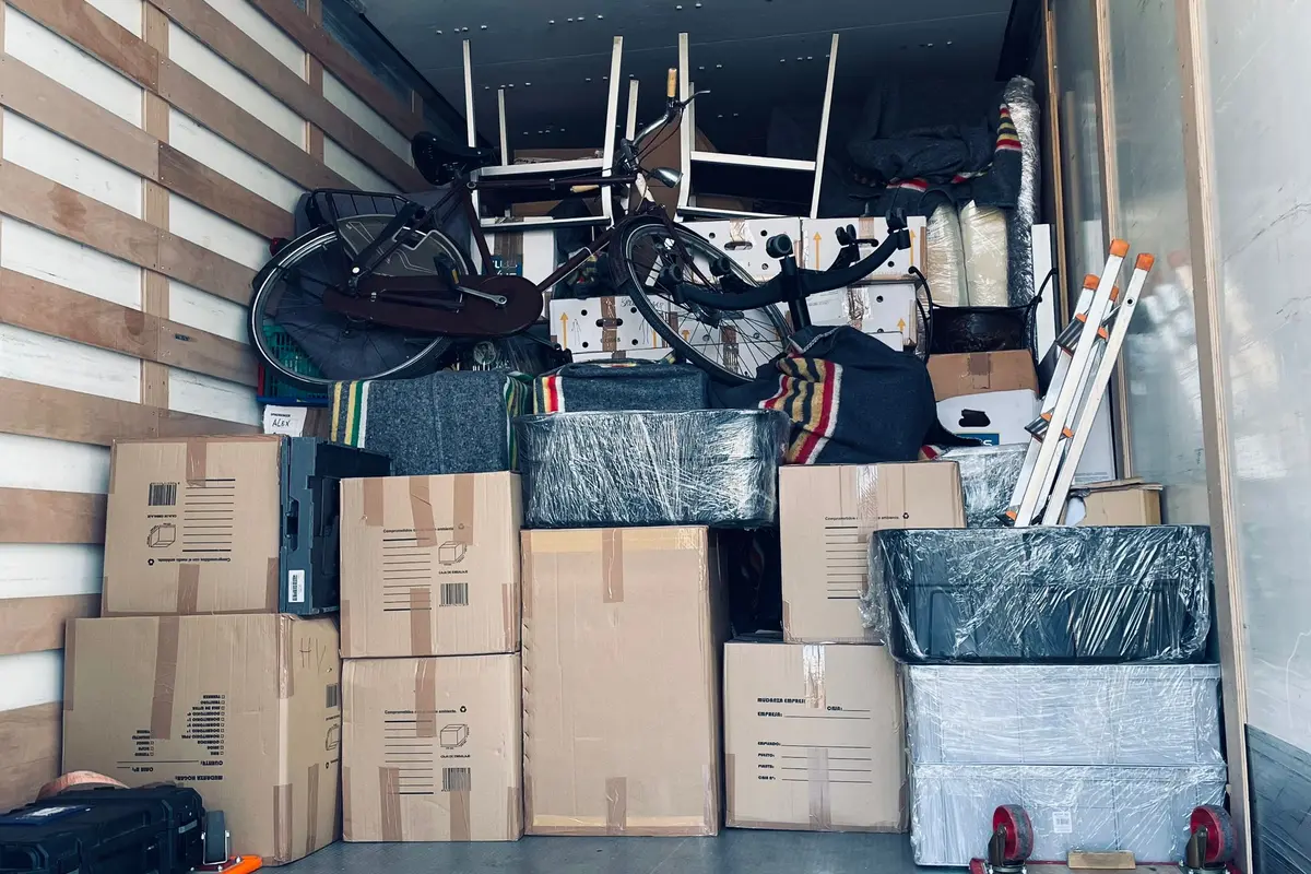 Volledig ingepakte verhuizing: dozen, meubels en fietsen gestapeld in bakwagen